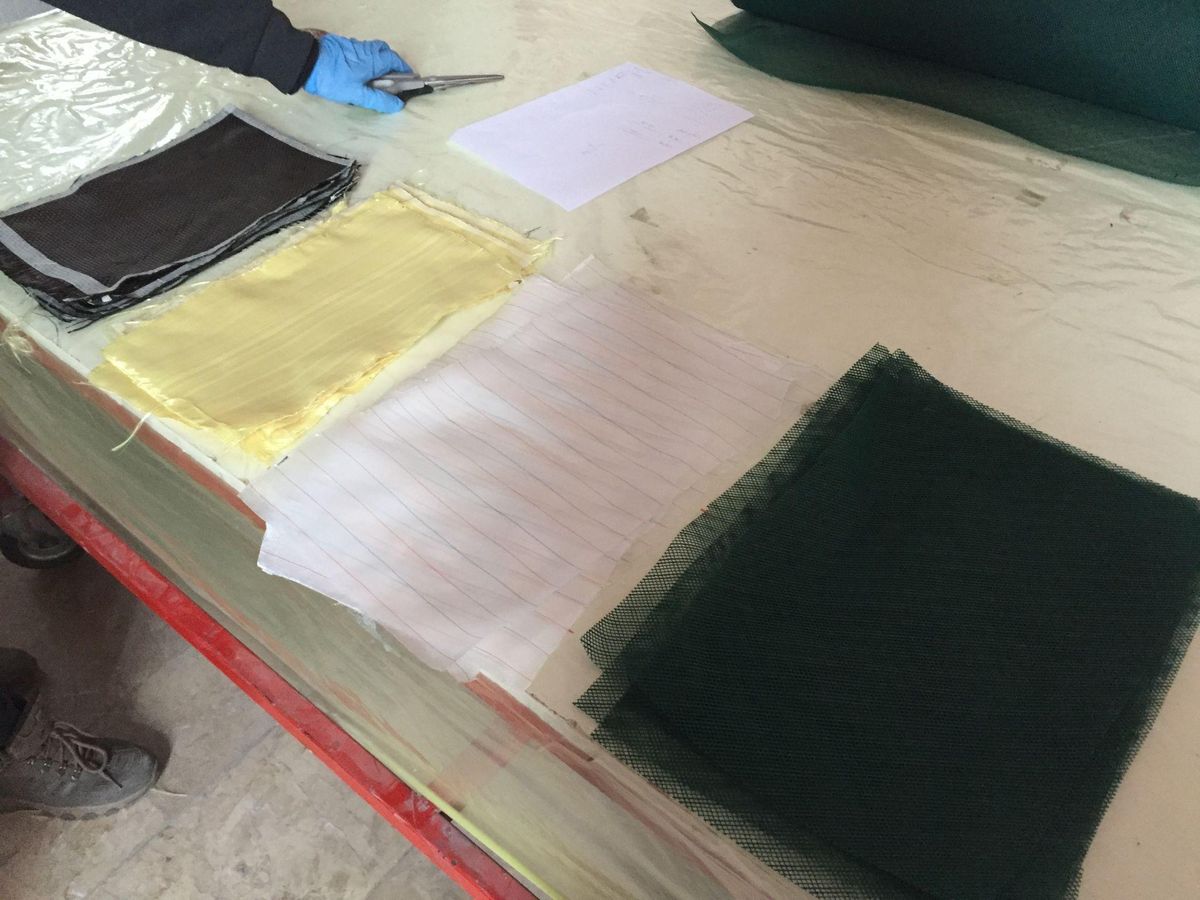 Carbon and Kevlar fabric layers prepared for composite lay-up